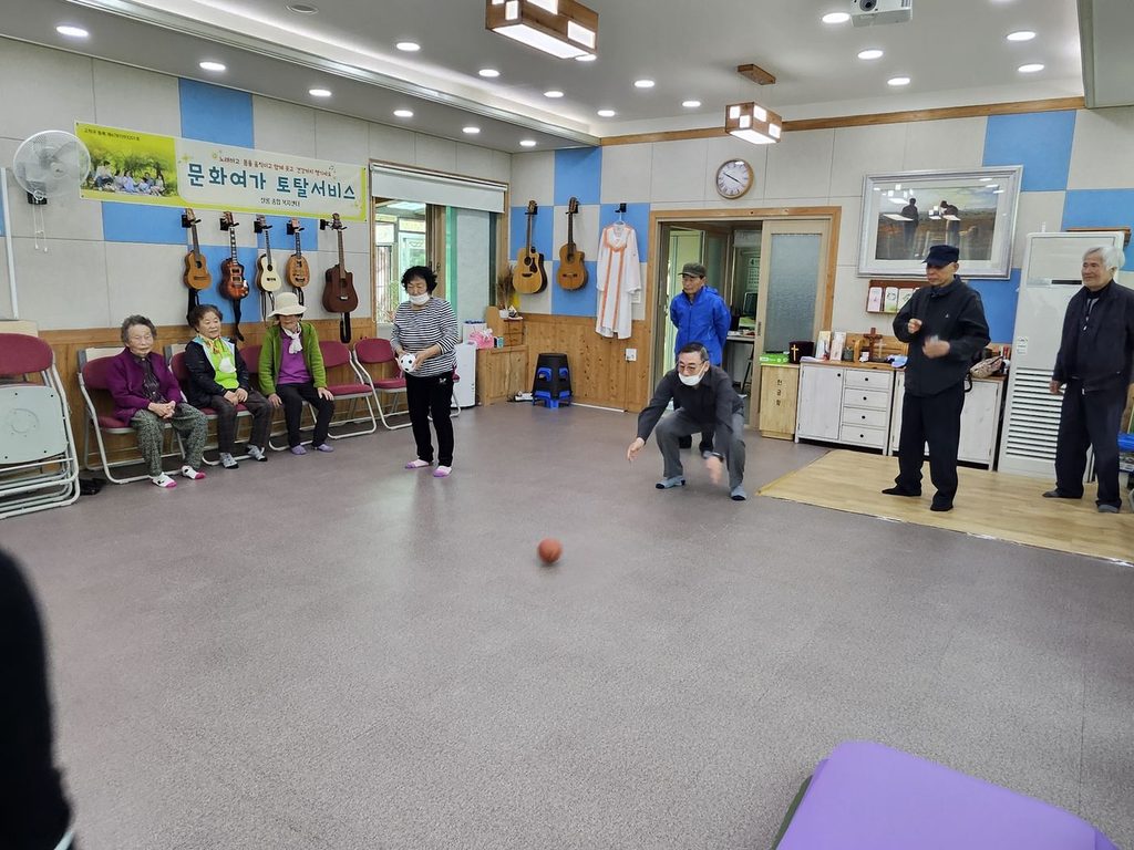 마을회관에서 함께 몸을 움직이는 프로그램에 참여하는 어르신들